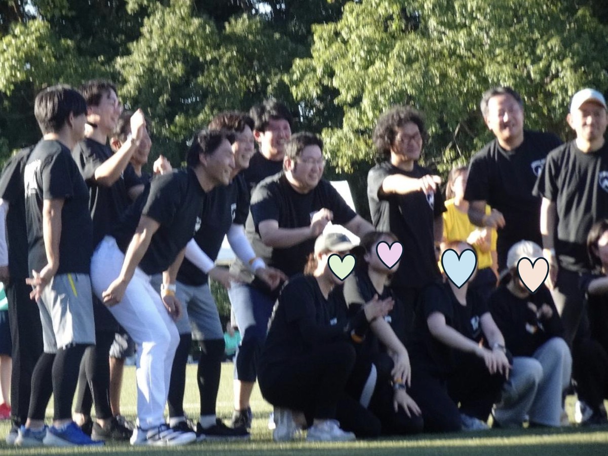 黒いTシャツのチームの集合写真